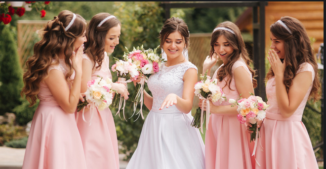 Bride and bridesmaids sharing joyful pre-ceremony moments.