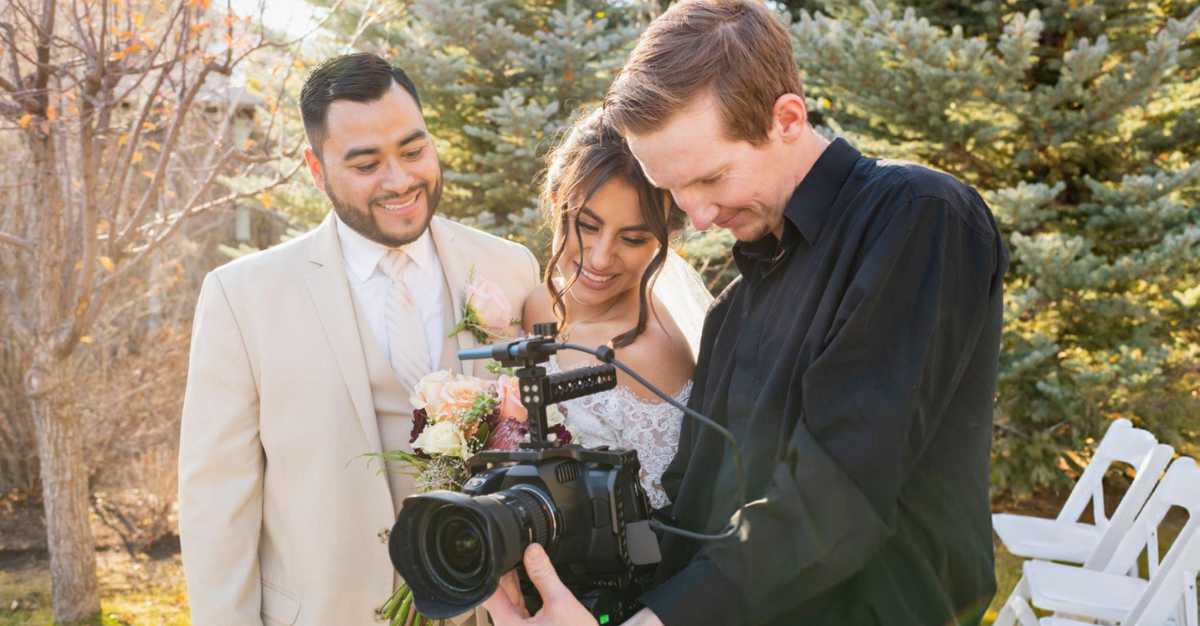 Couple enjoying their wedding video, highlighting the importance of a wedding videography checklist.